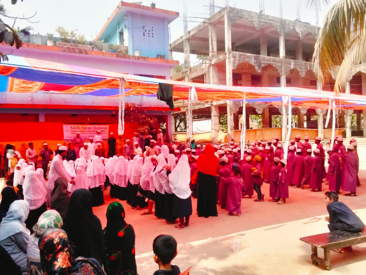 The madrasah courtyard with students gathered under a canopy